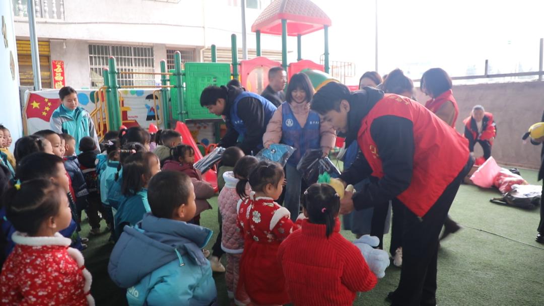 图为志愿者向幼儿园小朋友赠送礼物 图为志愿者向幼儿园小朋友赠送礼物